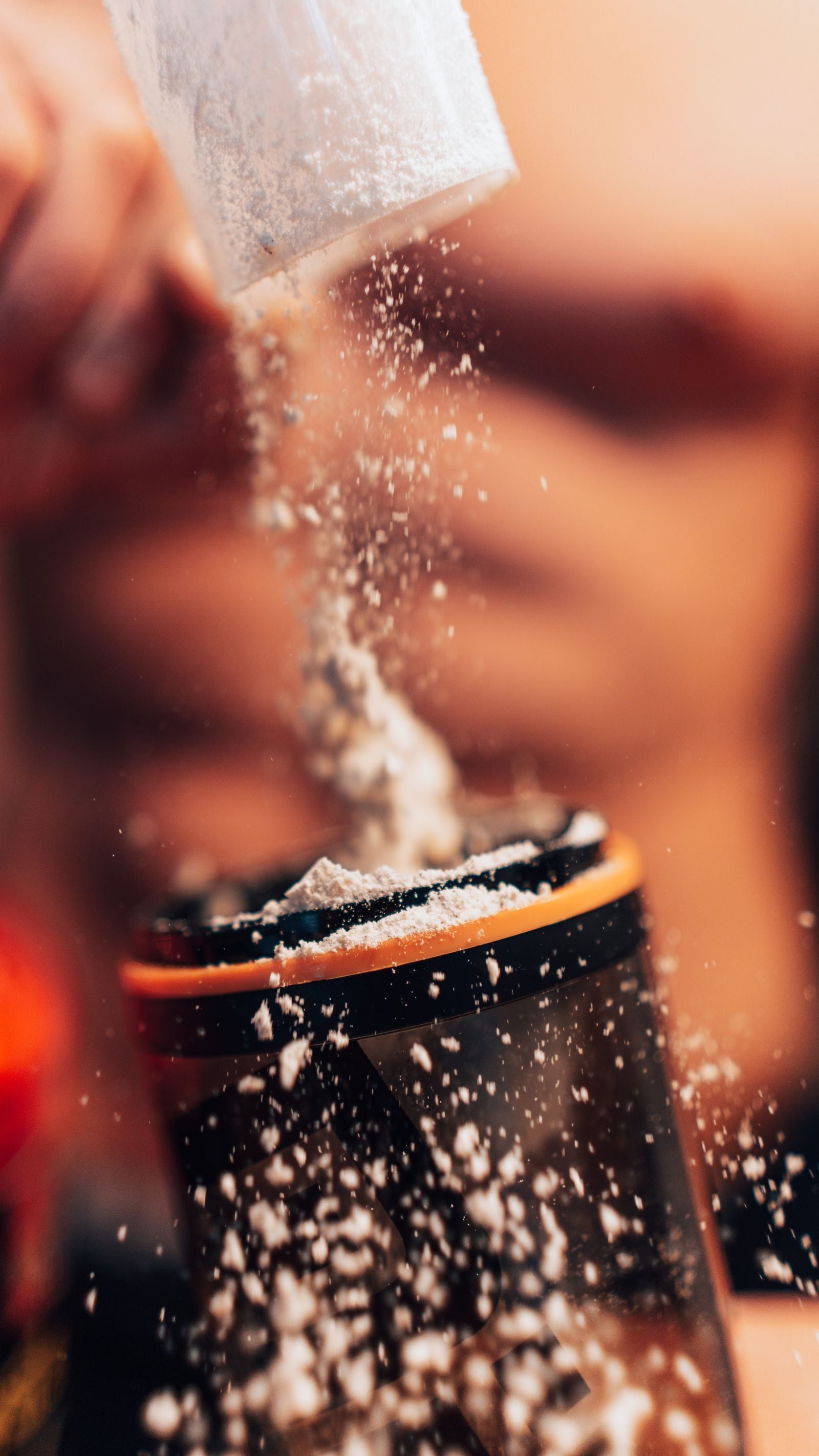 Protein powder being added to a shaker bottle