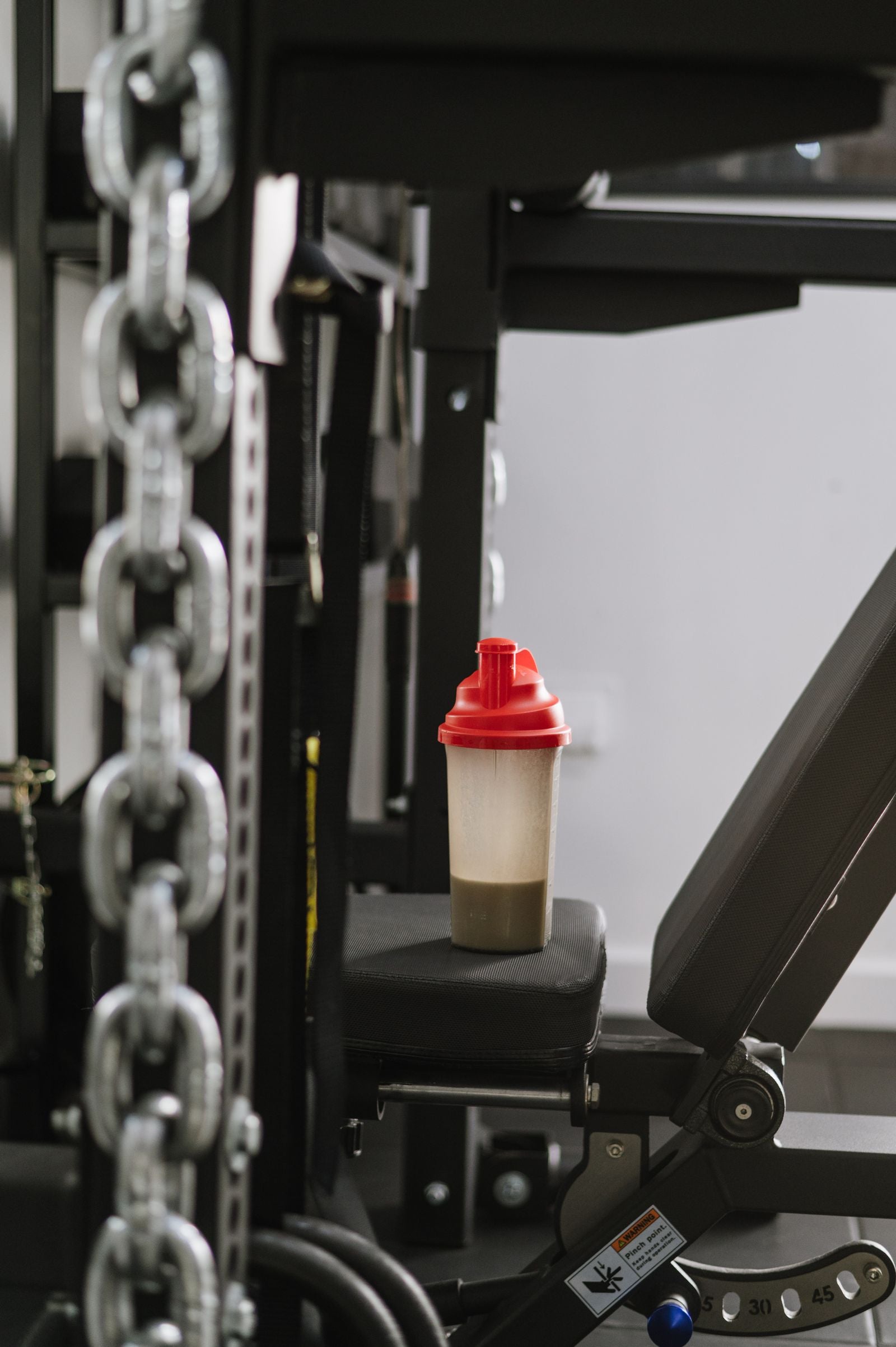 Protein shake bottle resting on gym equipment
