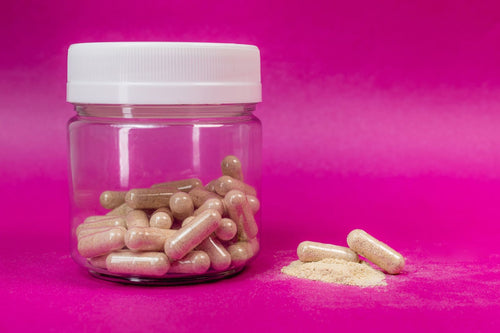 Jar of herbal capsules with powder