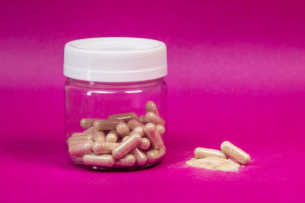 Glass jar of capsules on a bright background