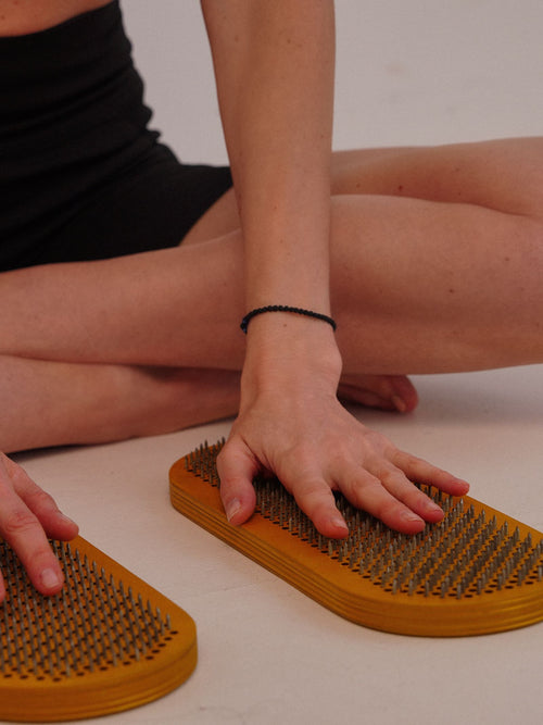 Woman relaxing on an acupressure mat in a studio