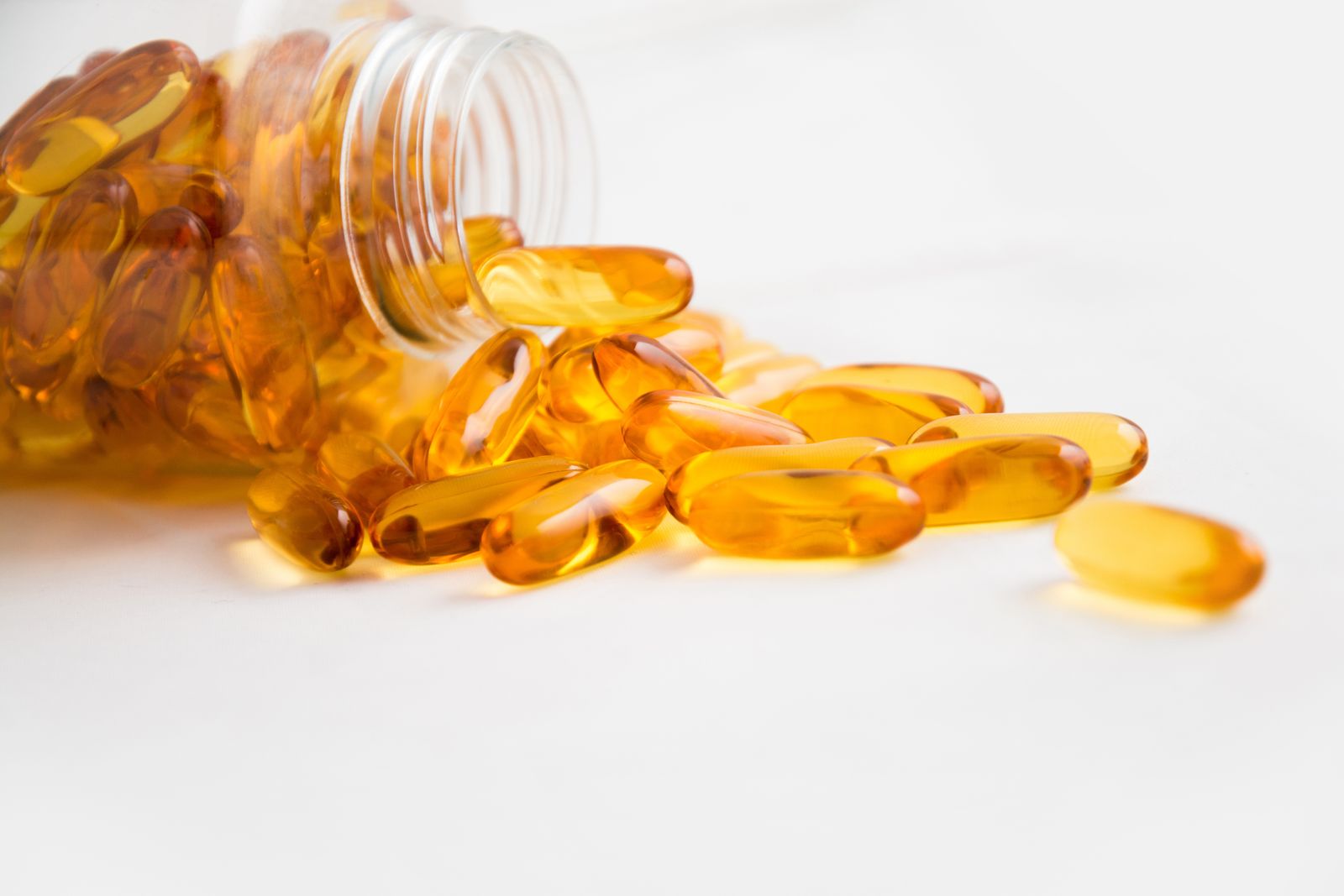 Fish oil capsules spilling from a bottle