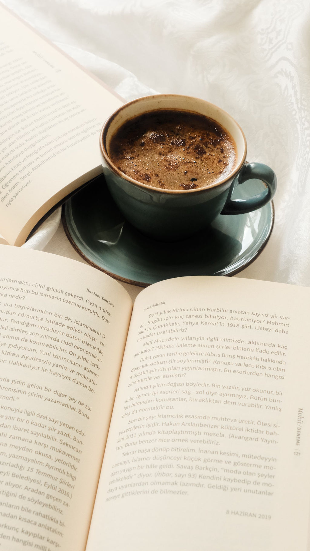 Open book beside a cup of coffee on a cozy morning