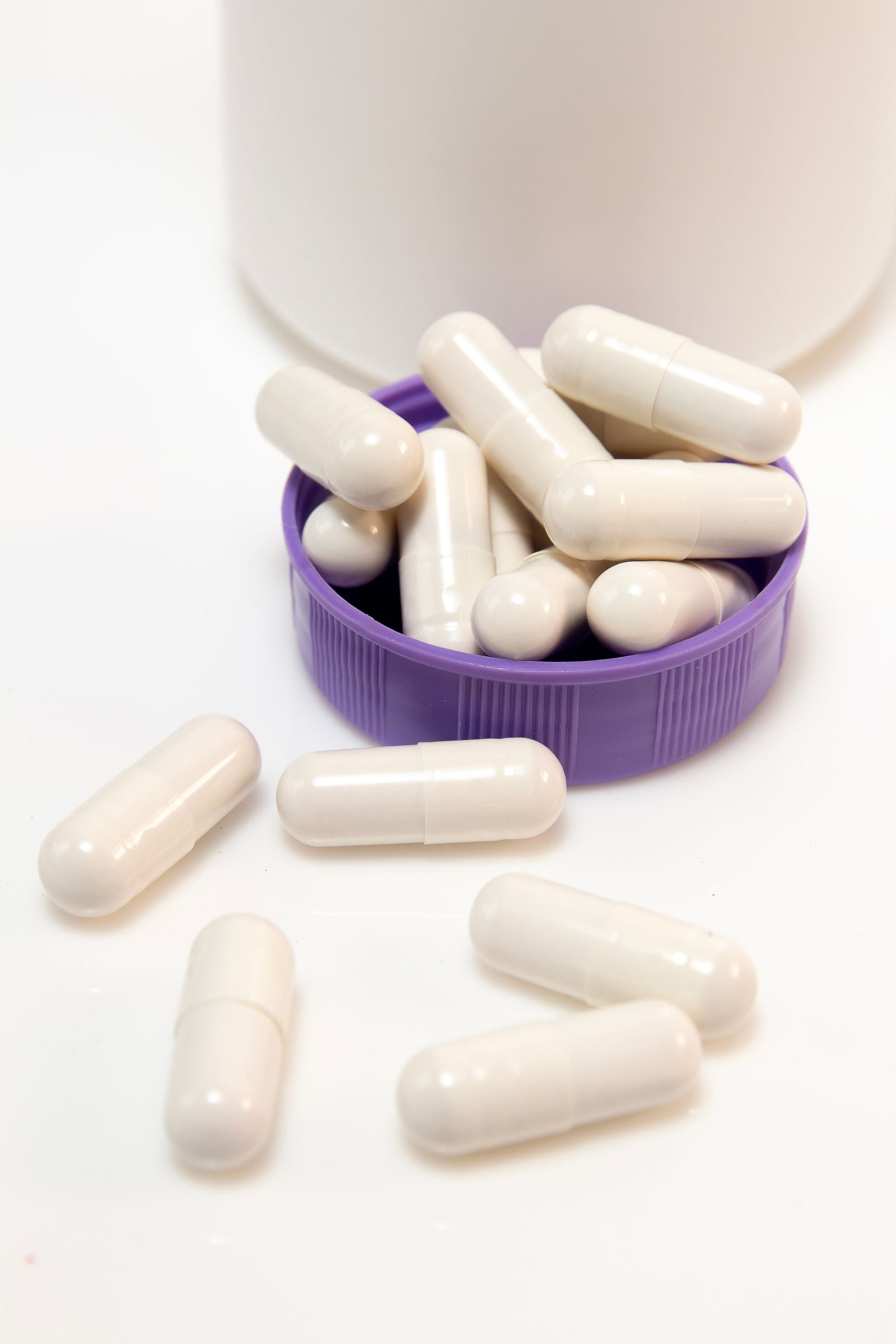 White capsules spilling from a container