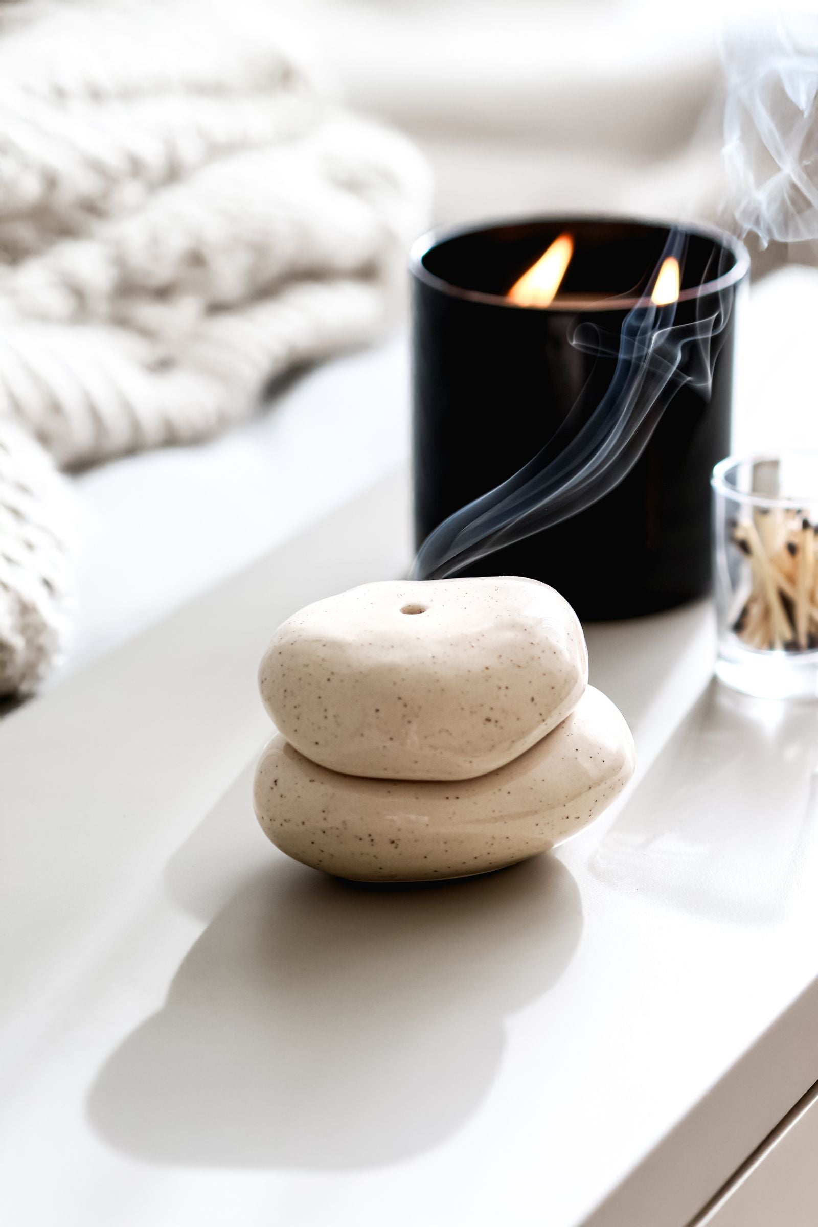 Spa arrangement with stacked stones and a lit candle