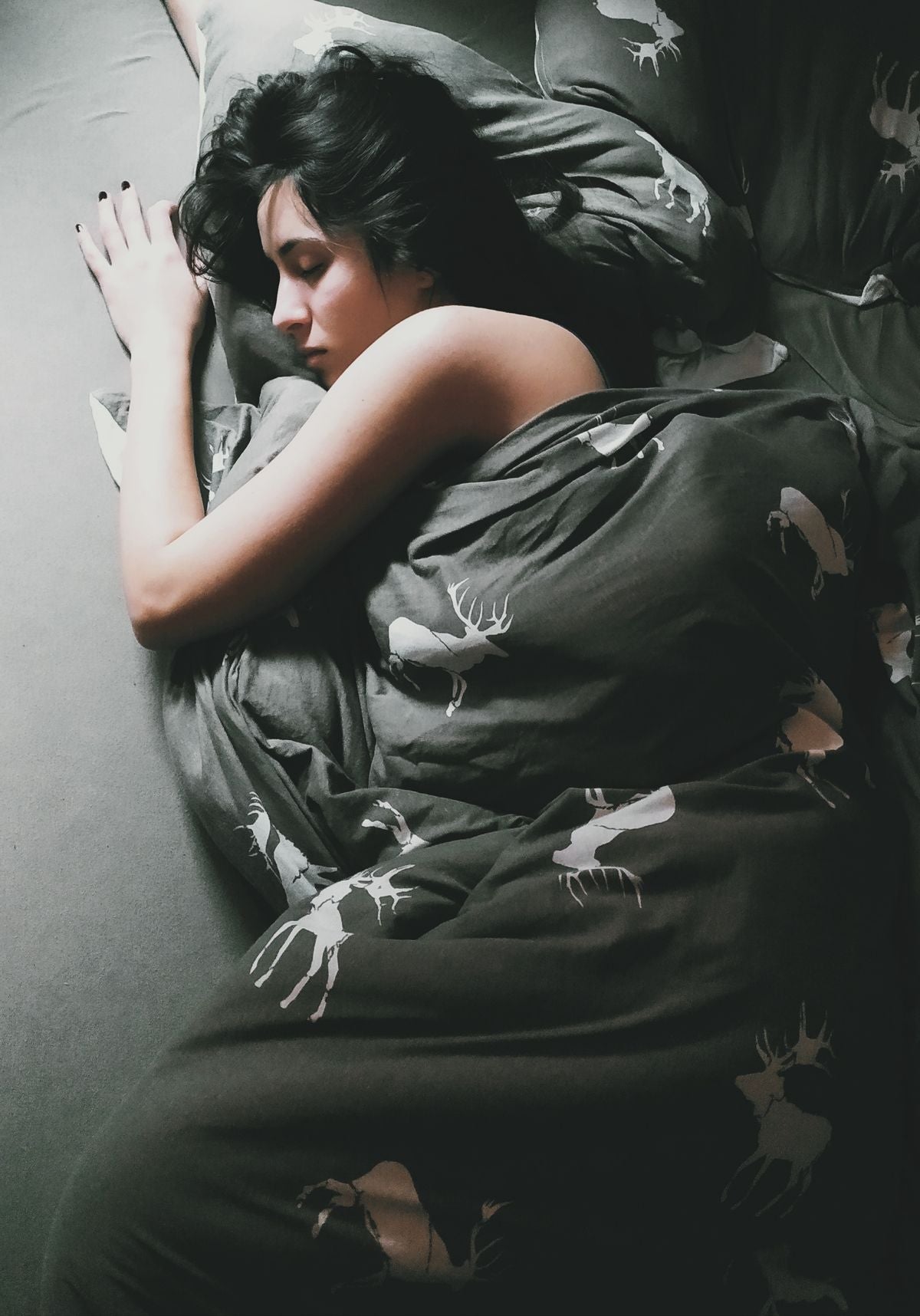 Woman sleeping peacefully in a cozy bed