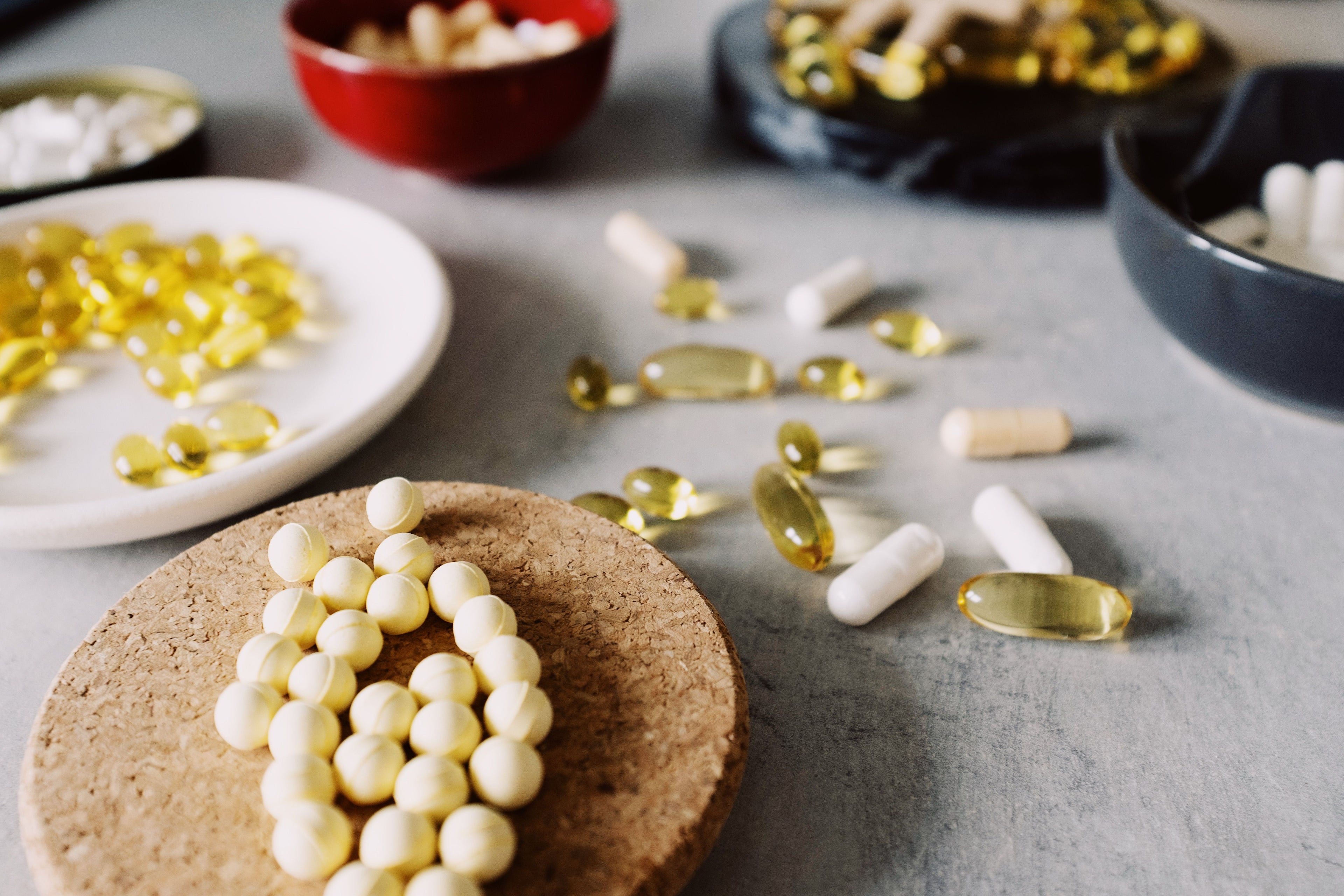 Supplement capsules and softgels on marble surface
