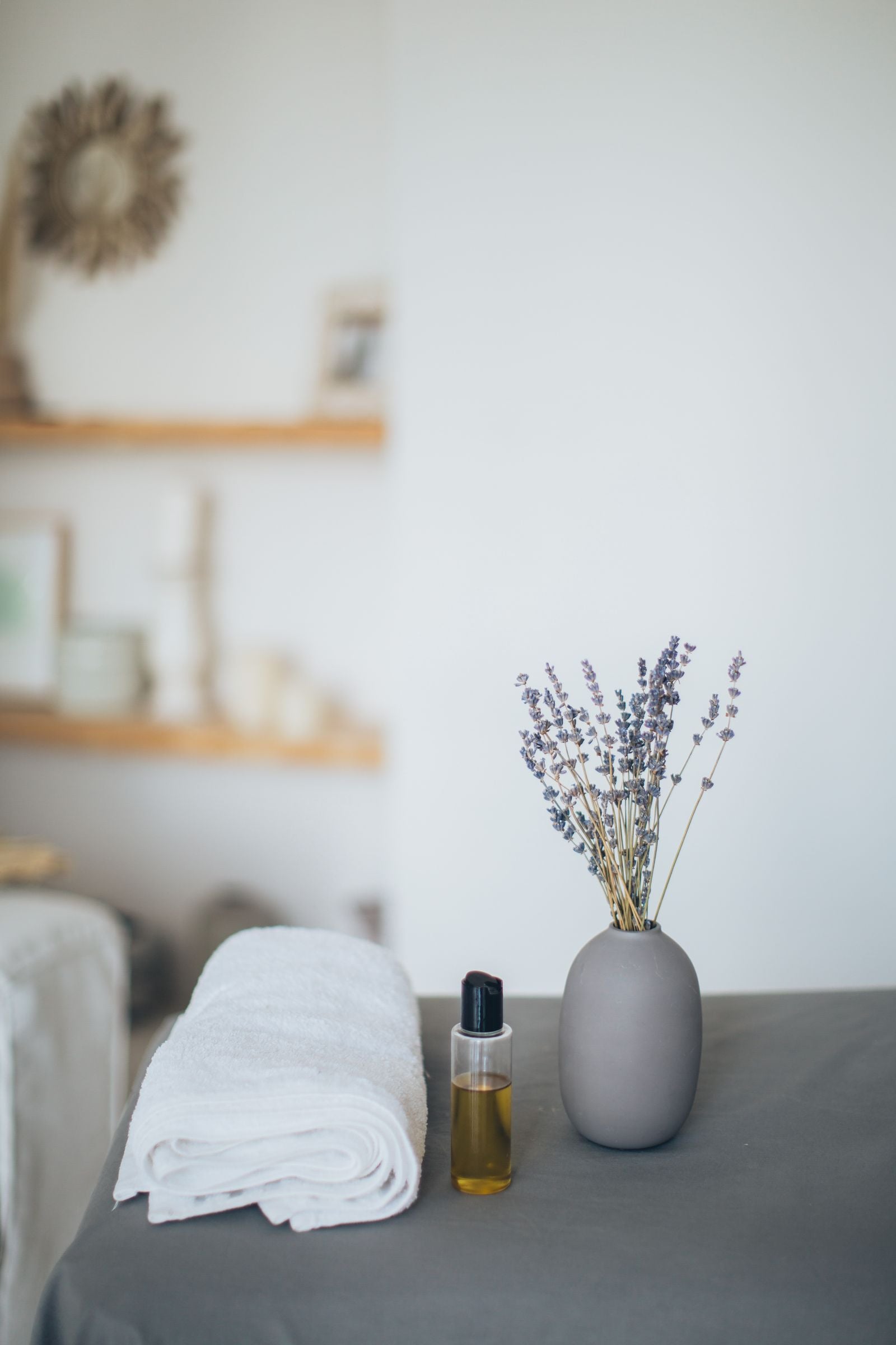 Calming spa scene with oil bottle, lavender, and towel
