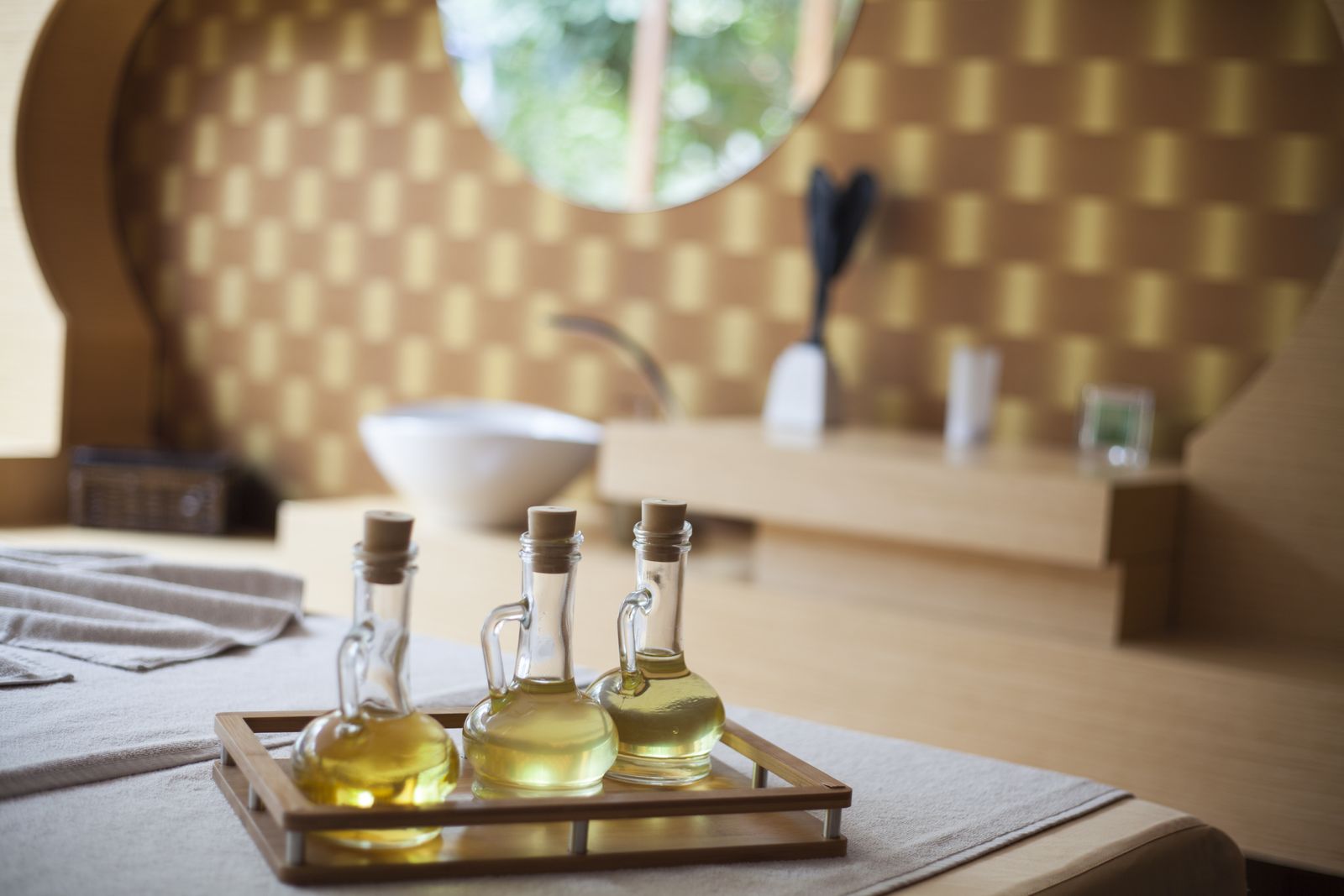 Natural oil bottles on a wooden tray in a spa room
