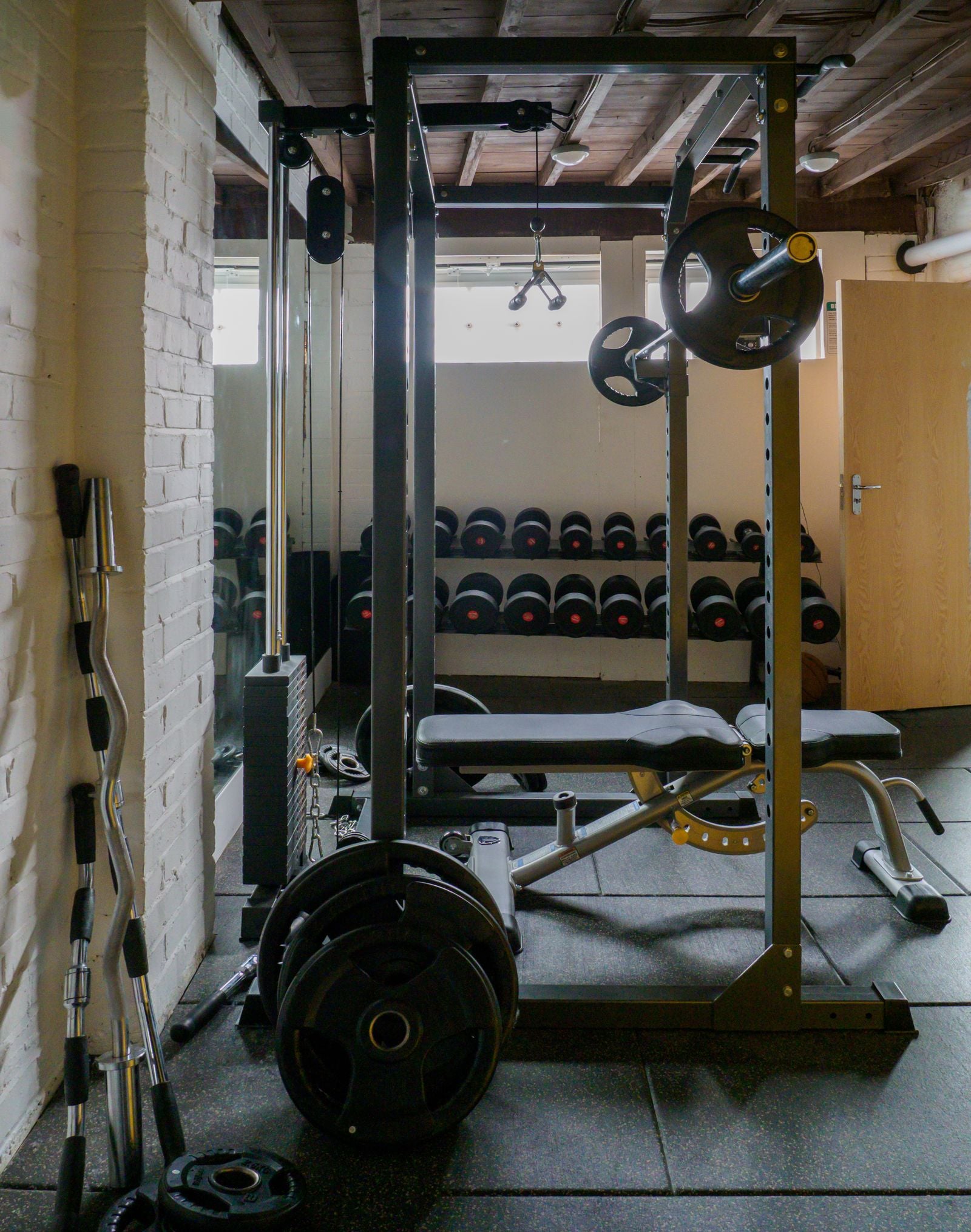 Home gym with bench press and dumbbells