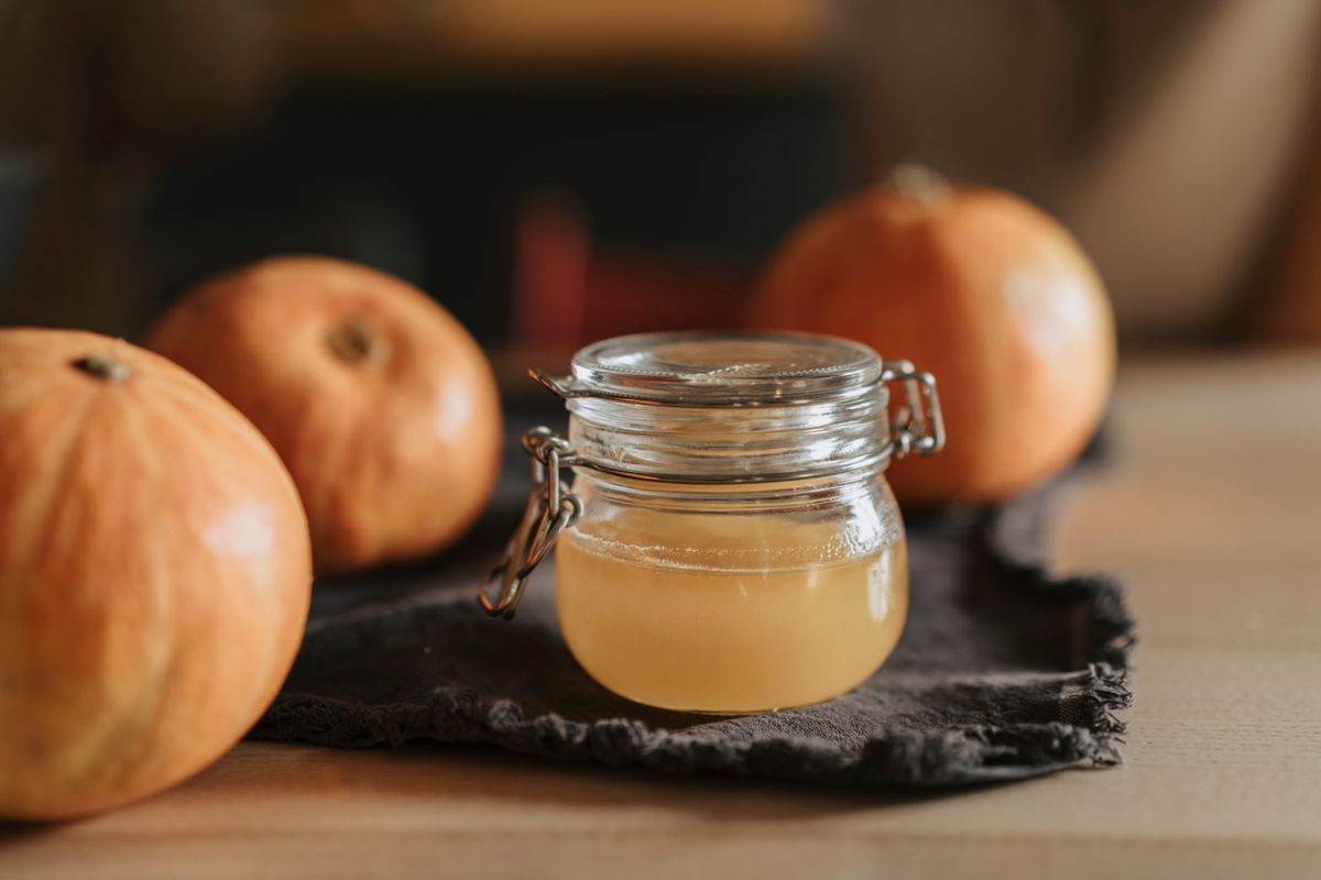 Apple cider vinegar in a glass jar with fresh apples