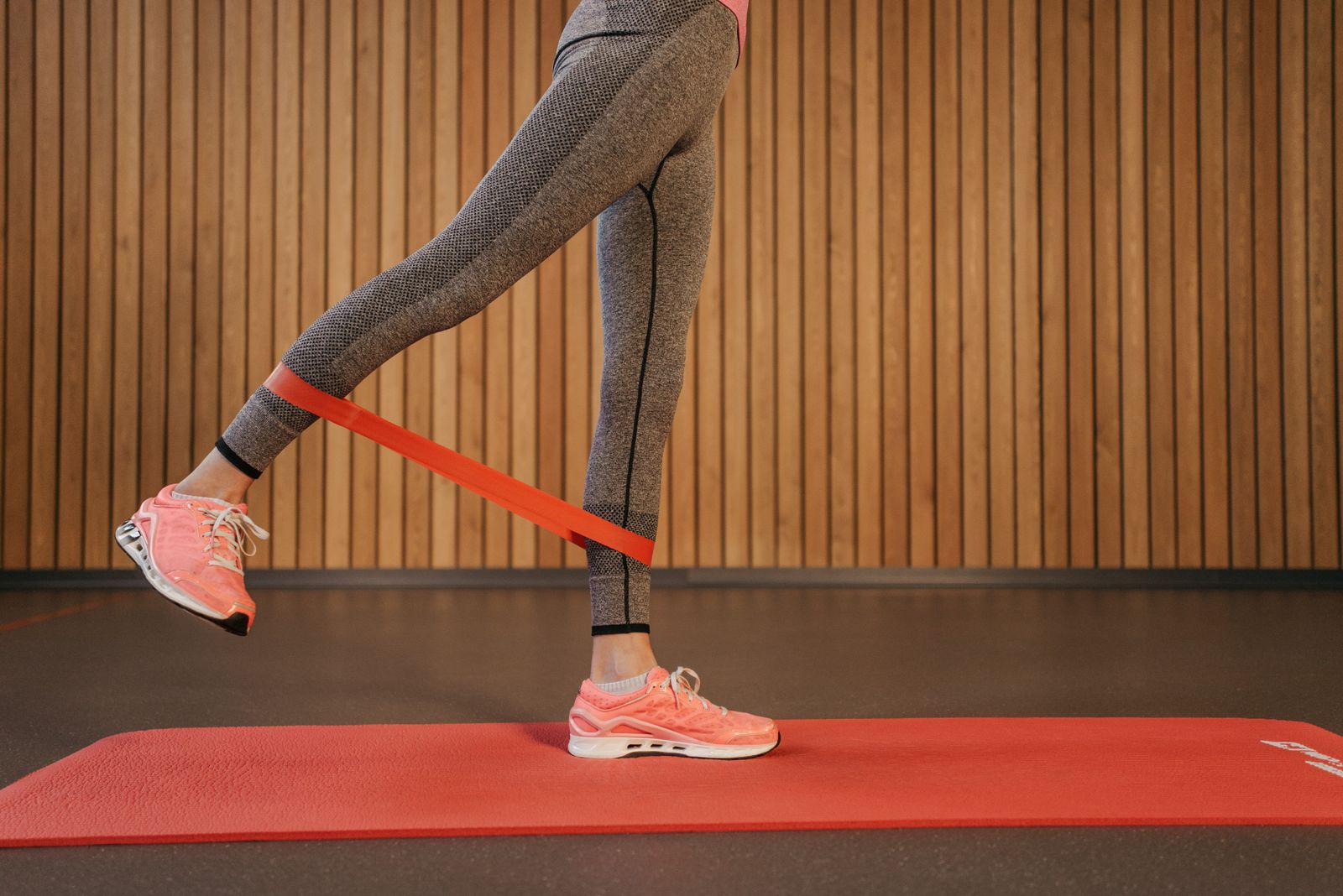 Woman doing leg exercises with a resistance band on a yoga mat