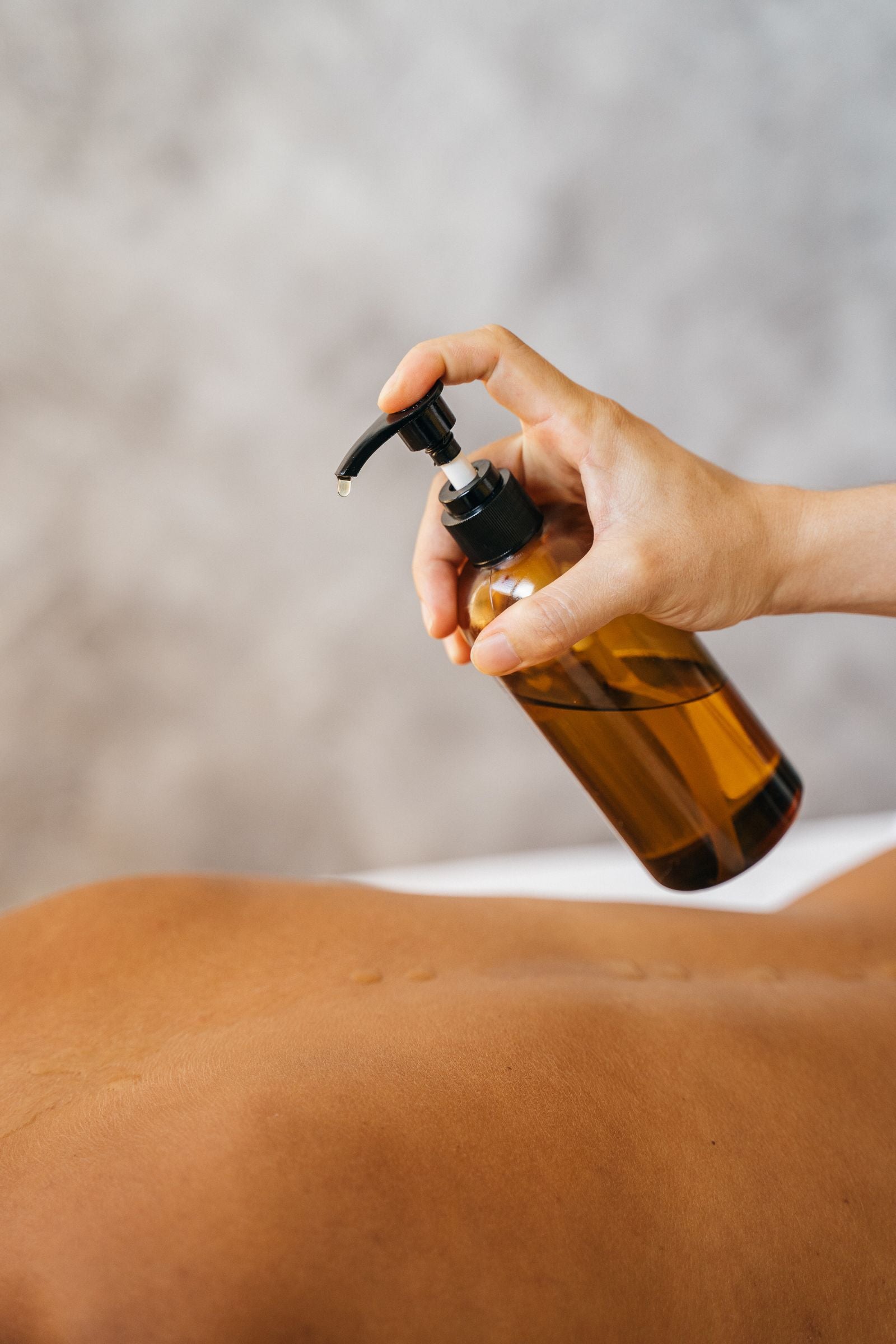 Massage therapist applying oil during a treatment