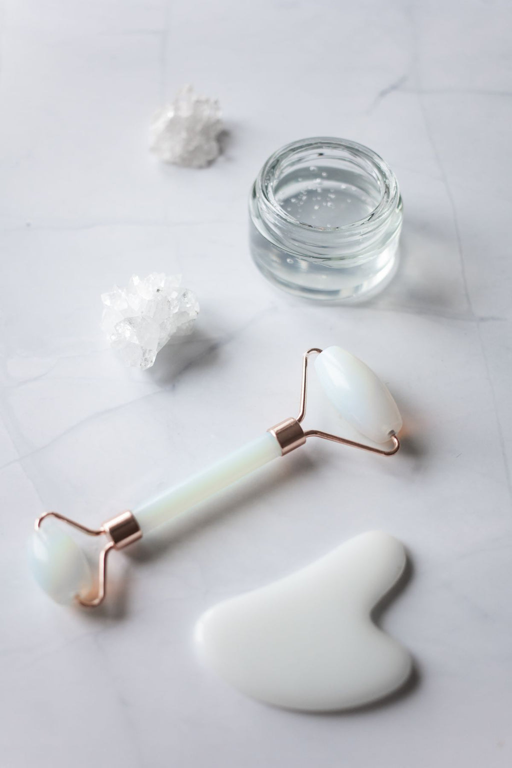 Jade facial massage tools arranged on a marble table