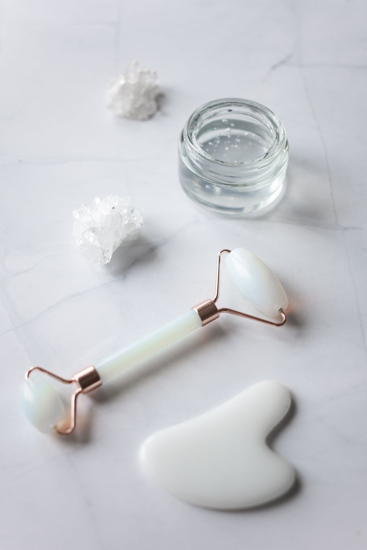 Jade facial massage tools arranged on a marble table