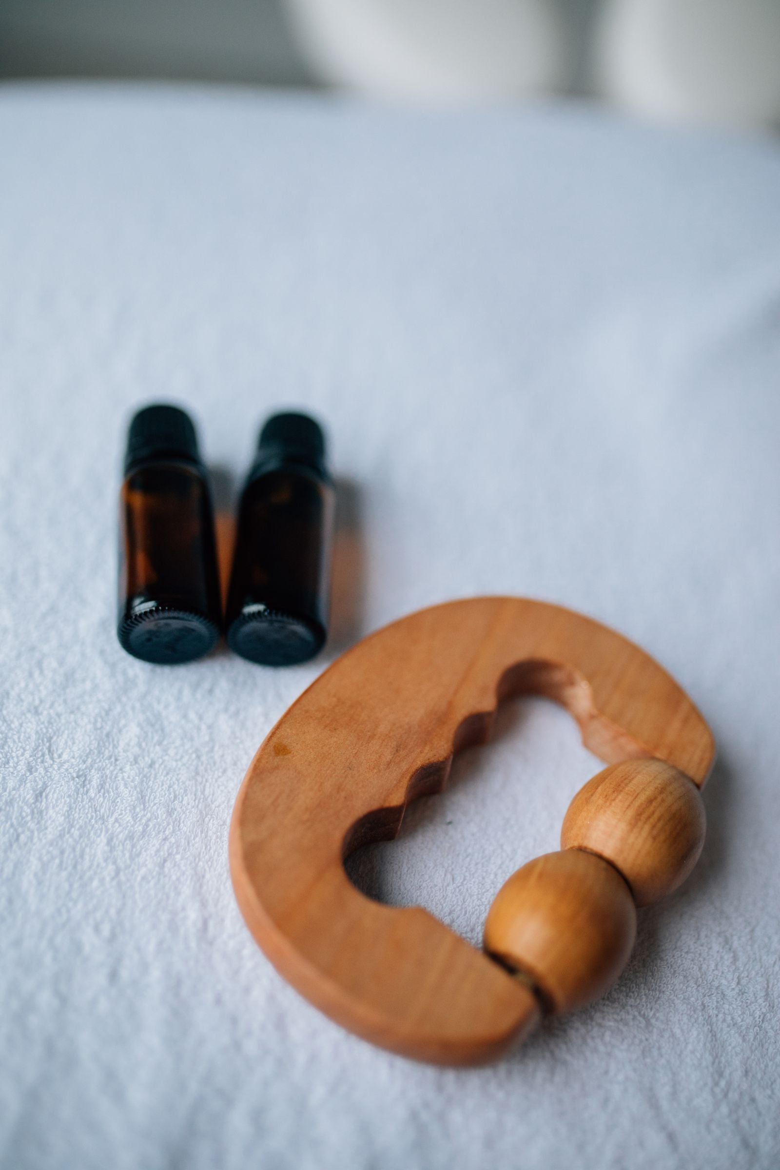 Oil bottles and a wooden massage tool