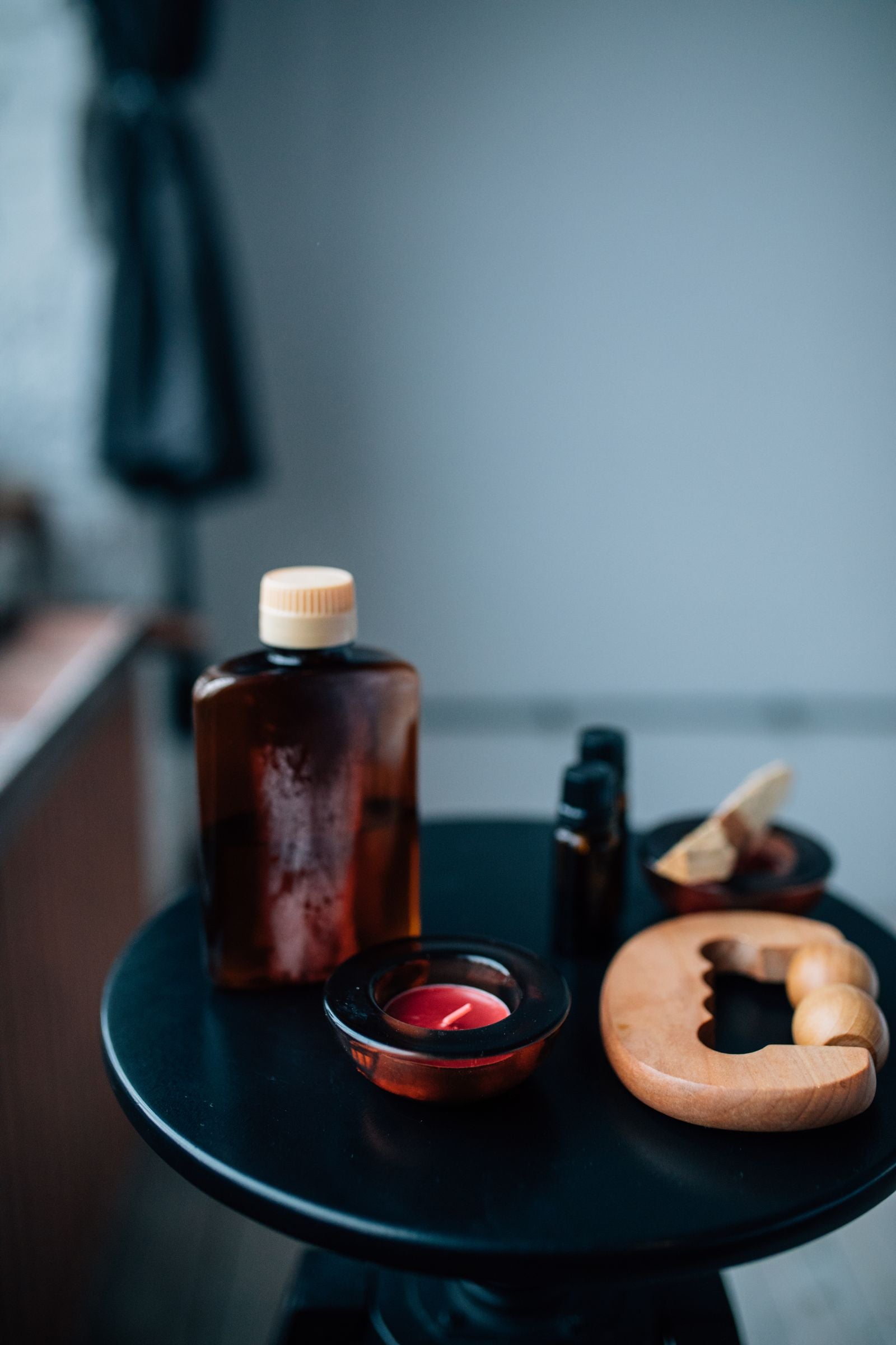 Aromatherapy bottles, candles, and massage tools on a table