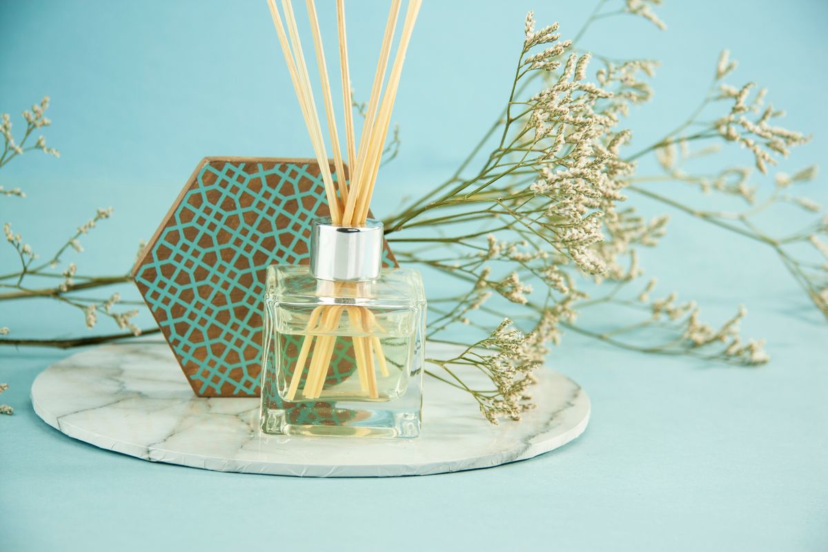 Aromatherapy diffuser with reed sticks beside natural branches