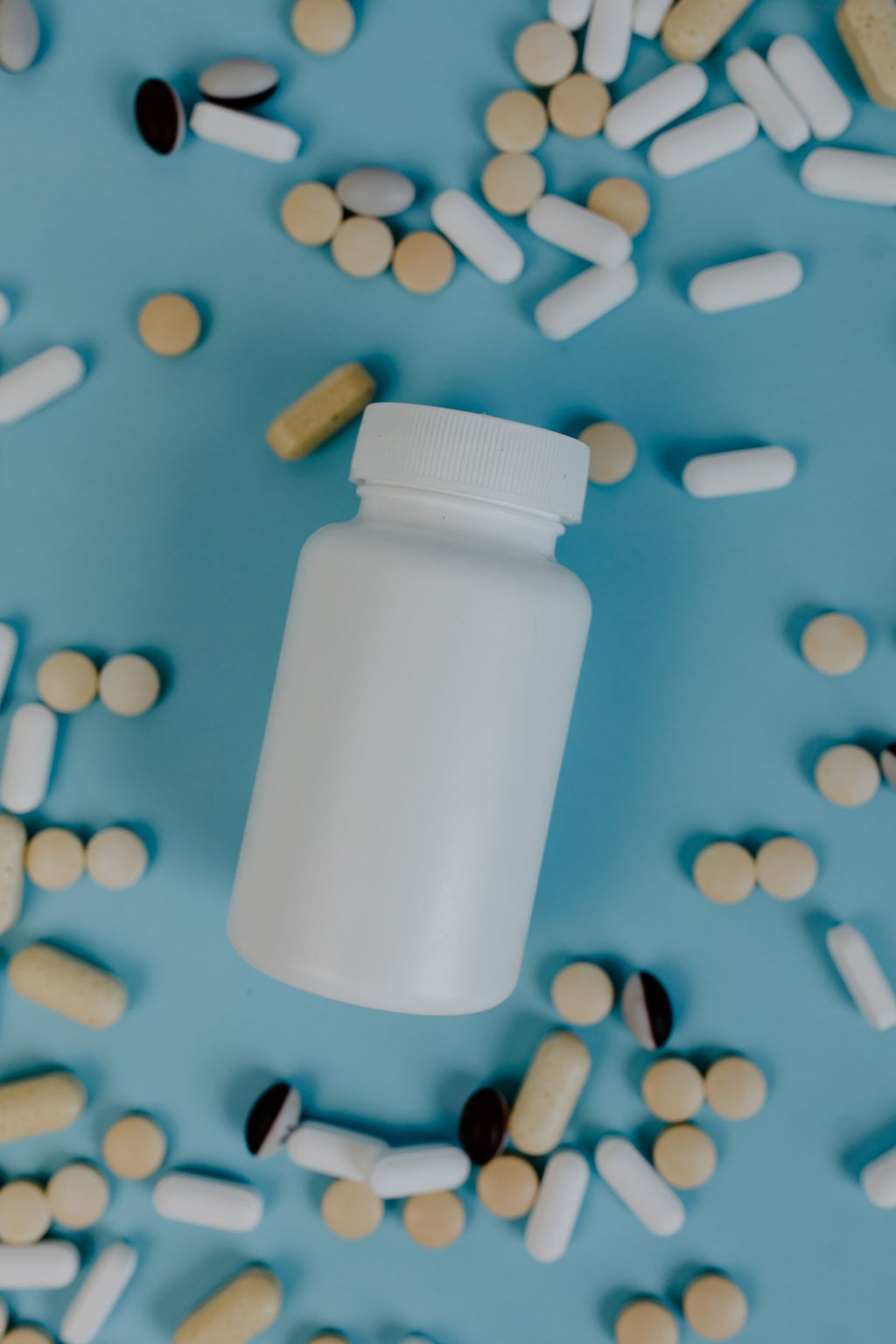 Supplement bottle with capsules on a blue surface