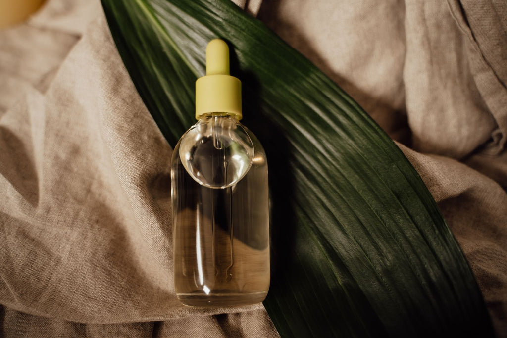 Glass dropper bottle of botanical oil on linen