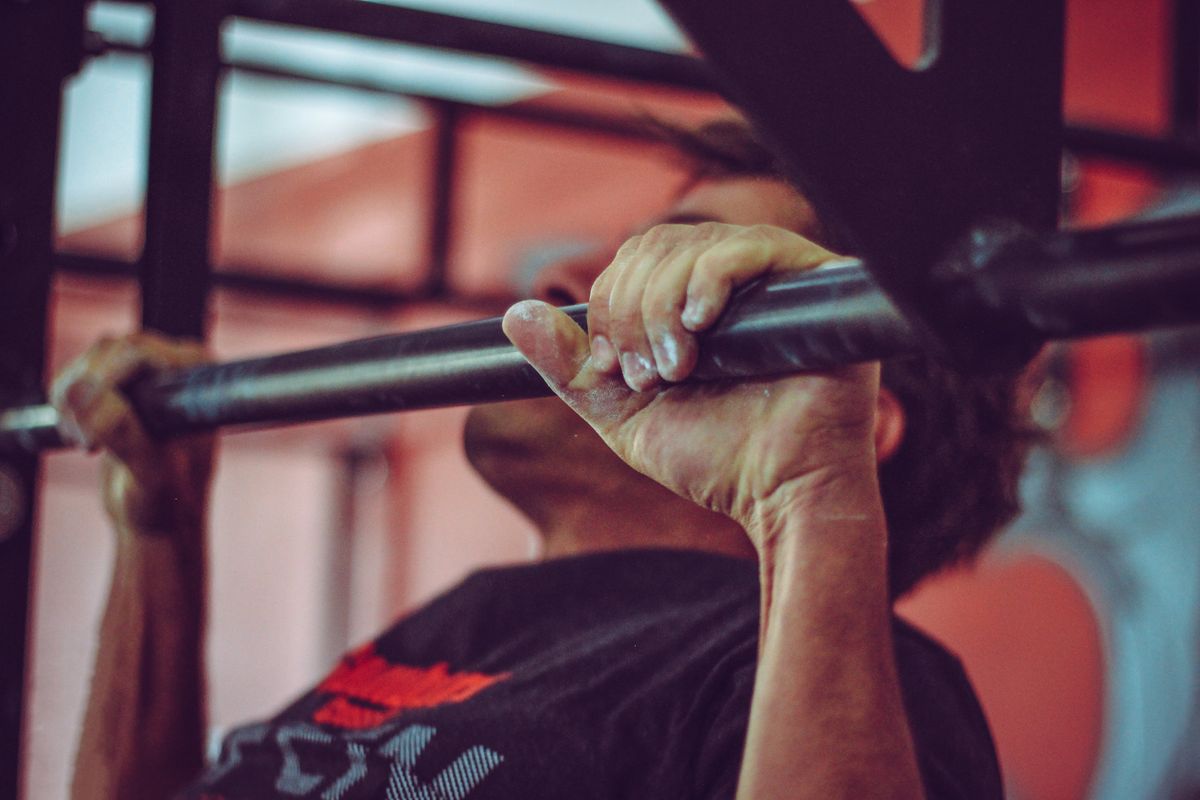 Athlete performing pull-ups on a bar