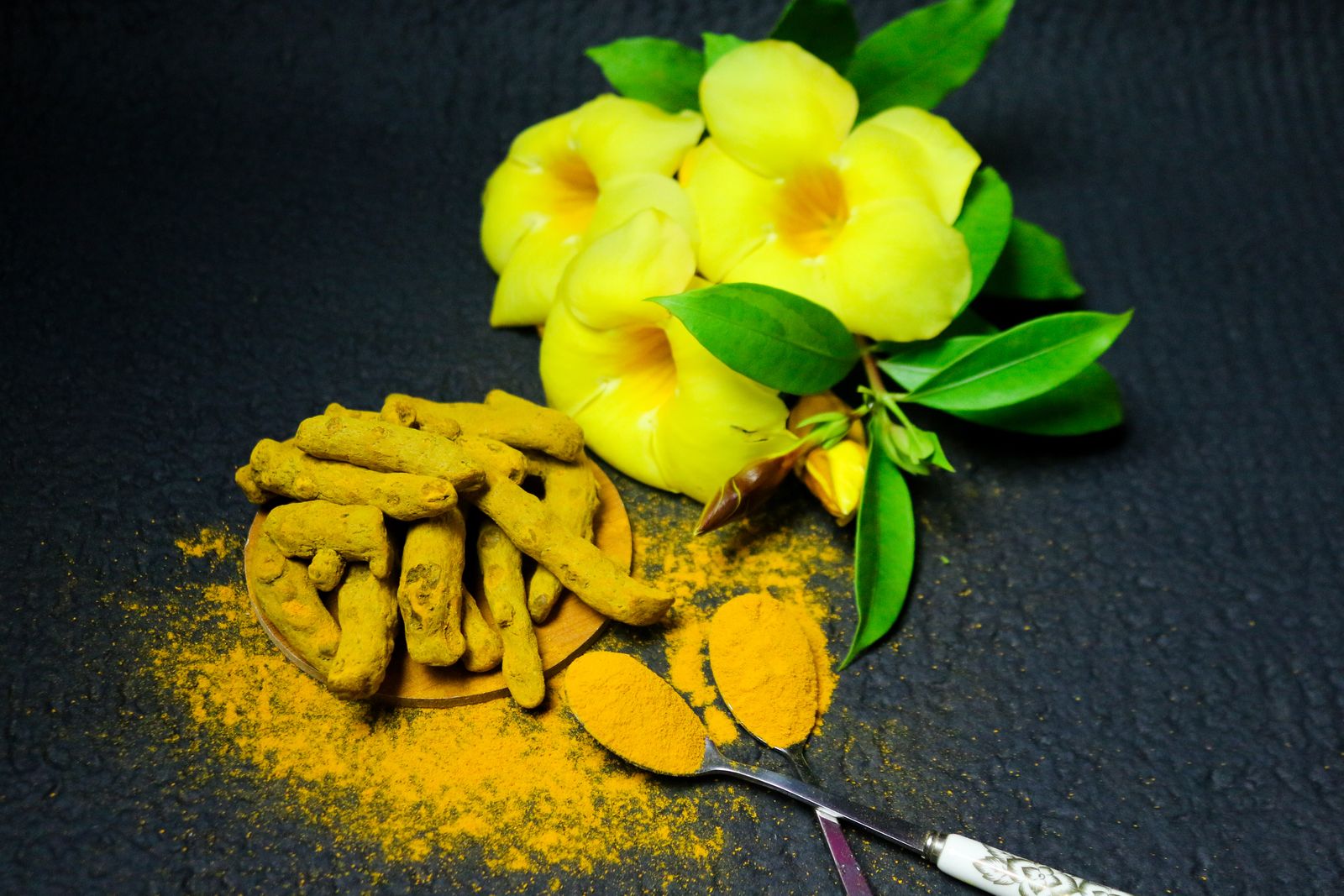 Turmeric root and powder with yellow flowers