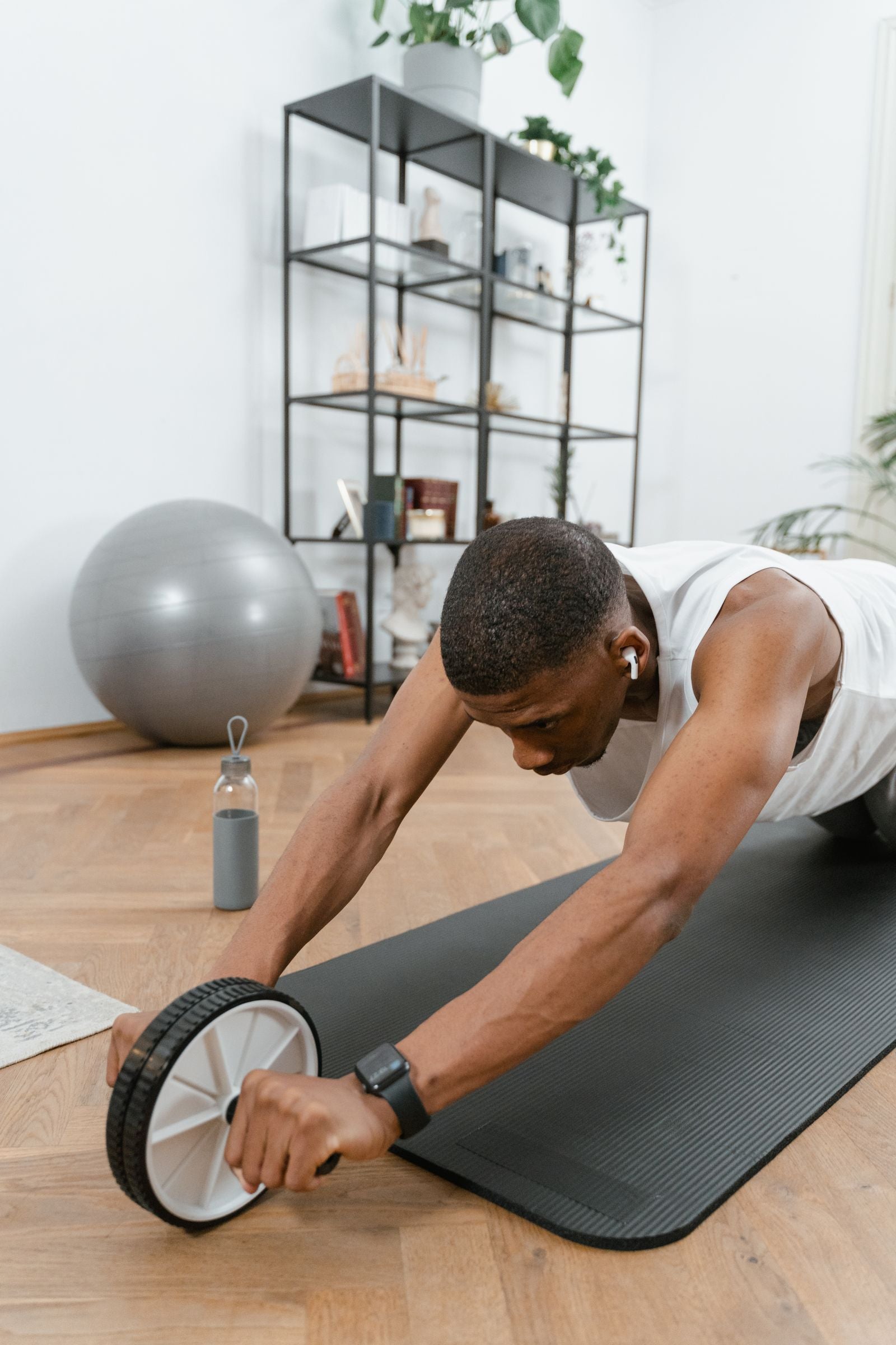 Man training with an ab wheel indoors
