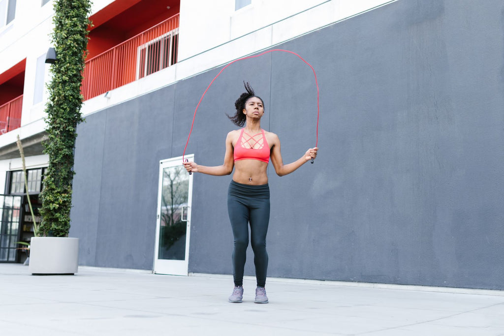 Woman jumping rope outdoors in the sunshine