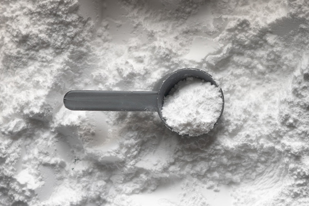 Collagen peptides white powder with measuring scoop