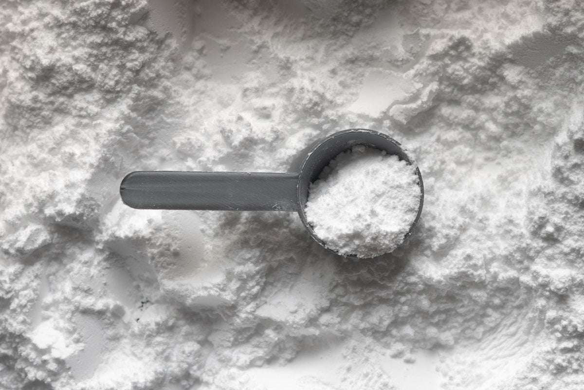 Collagen peptides white powder with measuring scoop